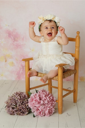 A Lovelly sitting up image of a young child in a chair with a pink background photography by Jayne Poole, Based in Great Torrington North Devon, Near Barnstaple, Fremington, Instow, Yelland, Croyde, Northam, Clovelly, Bude Holsworthy, Okehampton, Roundswell.